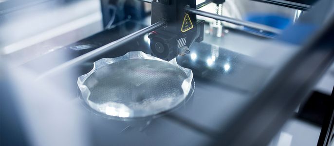 Ein 3D-Drucker in Aktion, der ein klares, transparentes Objekt herstellt.