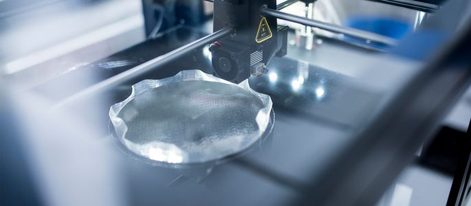 Ein 3D-Drucker in Aktion, der ein klares, transparentes Objekt herstellt.