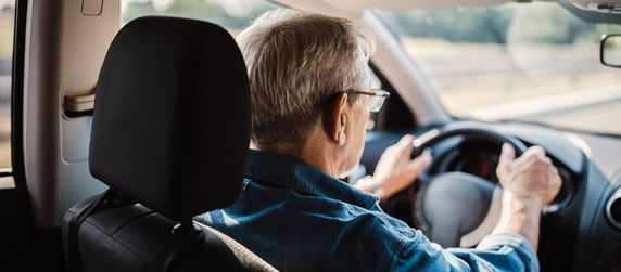 Eine Person beim Autofahren bei Tag.