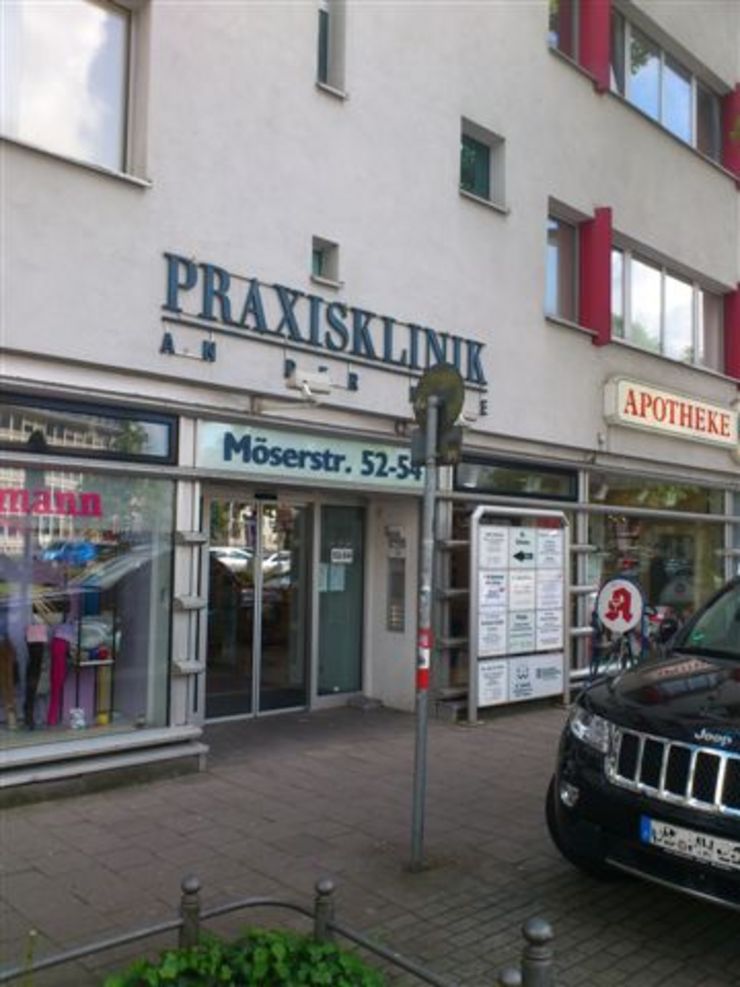 Ein Gebäude mit der Aufschrift "Praxisklinik". Vor dem Gebäude ist ein Auto geparkt.