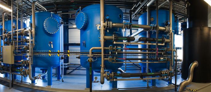 Eine große Industrieanlage mit blauen zylindrischen Tanks, die durch Metallrohre verbunden sind.