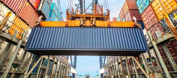 Ein Industriekran der einen Container in einem Containerlager hebt