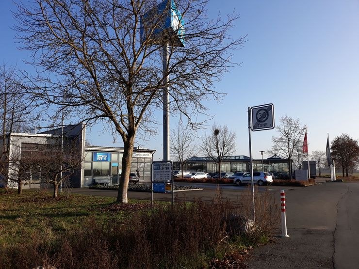 Ein modernes Gebäude umgeben von Bäumen und einem klaren blauen Himmel.