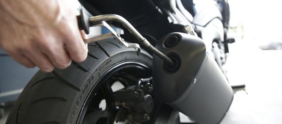 Ein Motorradauspuff in dem ein Rohr steckt