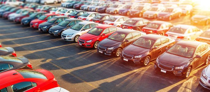 Ein großer Autoabstellplatz mit aufgereihten Autos.