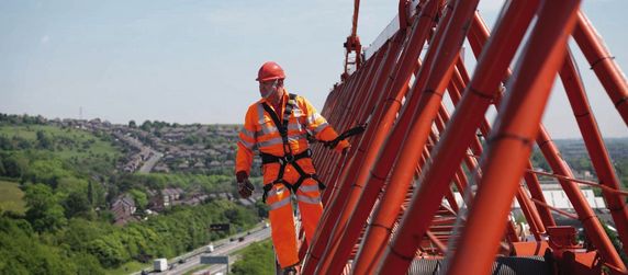 Ein Bauarbeiter der auf einem Krahn steht