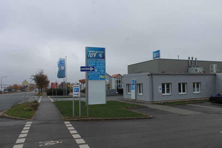 Ein Gewerbegebiet mit einem "TUEV Hessen"-Schild, einem Gebäude und einem Parkplatz.