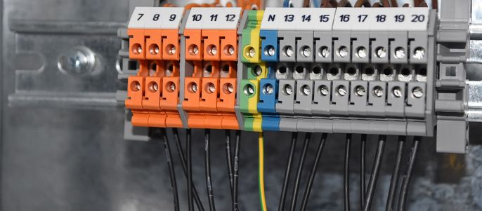 Eine Reihe von farbcodierten Klemmenblöcken mit Nummern von 7 bis 20, verbunden durch schwarze Drähte.