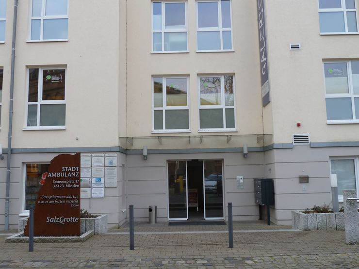 Die Außenseite eines Gebäudes mit einem Schild, auf dem "STADT AMBULANZ" und "Simeonsplatz 17 32422 Minden" steht.