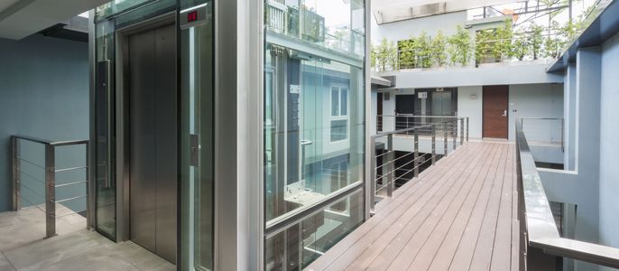 Gläserner Aufzug in einem Gebäude bei Tag