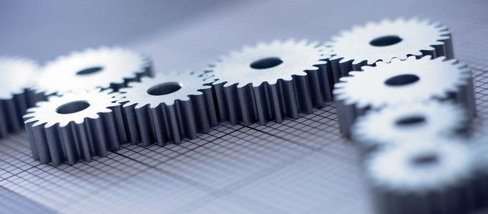 Eine Reihe von Zahnrädern, die auf einem Millimeterpapier angeordnet sind.