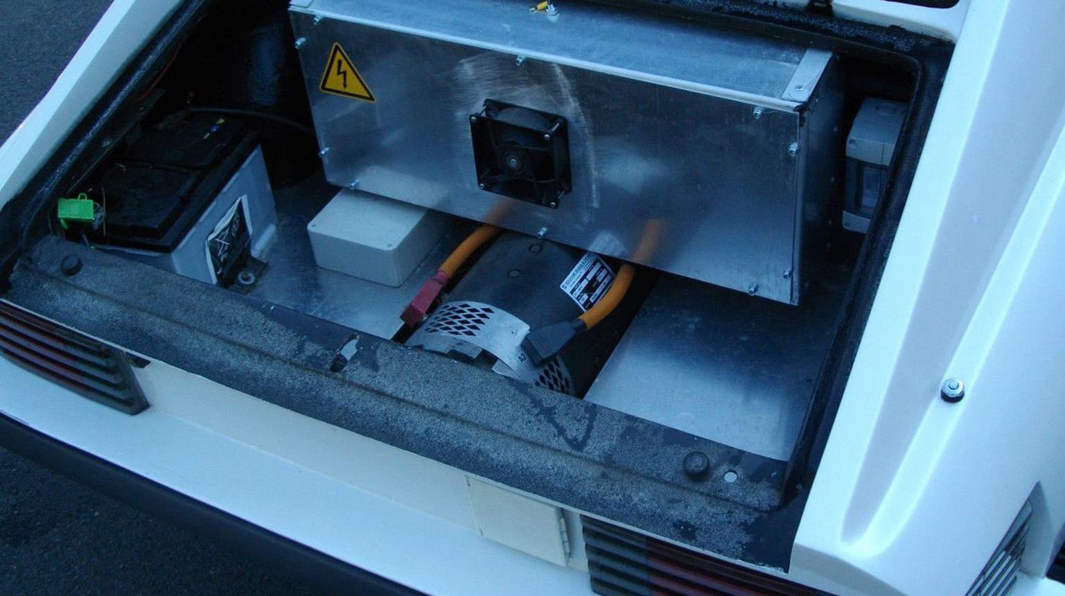 Eine Autobatterie in Auto mit geöffneter Motorhaube.