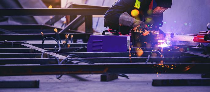 Ein Schweißer am schweißen eines Metallrahmens.